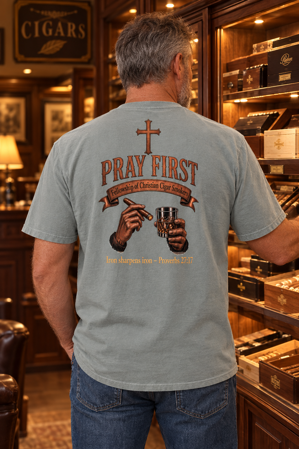 Man in Granite Iron Sharpens Iron tee browsing a cigar shop, back view