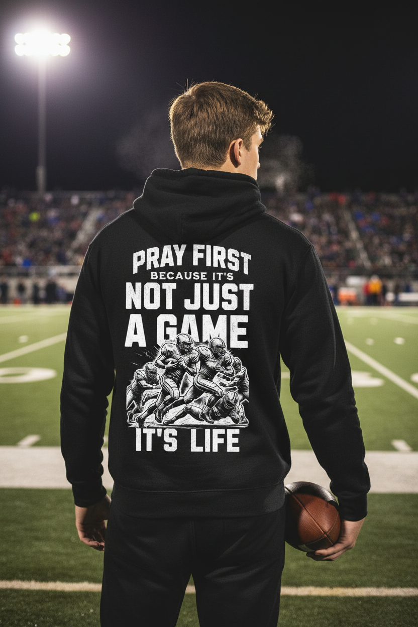 Back view of Godspeed Vikings Pray First hoodie worn at a football stadium at night